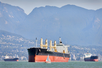 Fototapeta premium Freighters and Sailboats, Vancouver. English Bay at work and play. Vancouver, British Columbia, Canada.