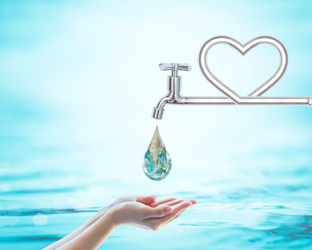 Green globe drinking drop from heart water tap on woman human hand on natural blue ocean background: World environmental concept: Saving water conceptual csr idea: Element of image furnished by NASA