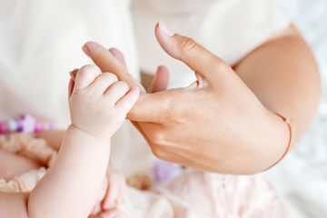 Fototapeta na wymiar Newborn children's hand in mother hand. Mom and her Child
