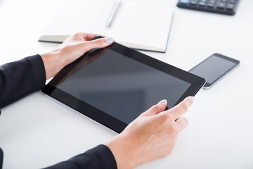 Woman's hands with purple nail polish holding tablet