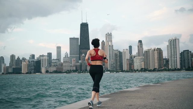 Runner athlete running on the background of skyscrapers and seaside