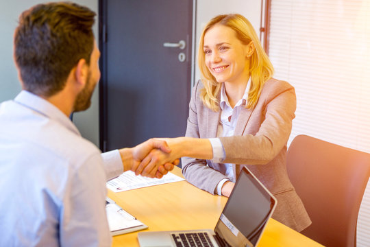Young attractive woman handshaking at the end of a job interview