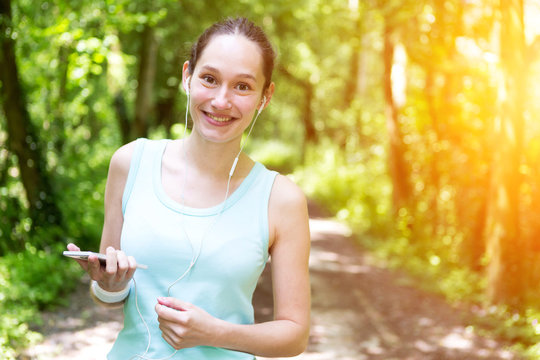 Young attractive woman setting her mobile in armband before runn