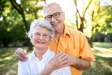 Happy senior couple hugging in park
