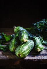 Fresh organic cucumbers. Vintage wooden background. Low key