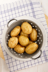 washed and wet potatoes in a colander