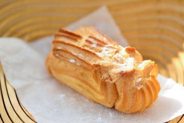 One Eclair with the cream in a wooden vase