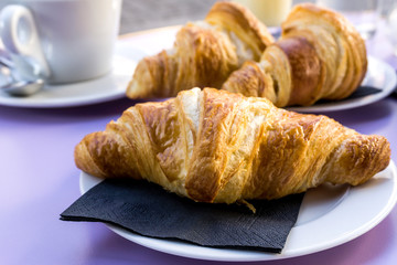 Breakfast with coffee and croissants on table
