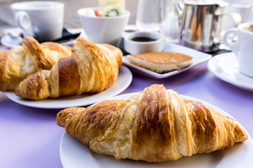 Breakfast with coffee and croissants on table