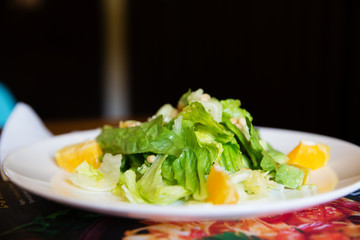 Fresh greens salad on a white plate