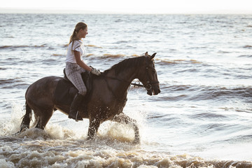 Pretty girl riding horse in river water