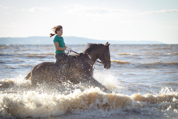 Pretty girl riding horse in river water