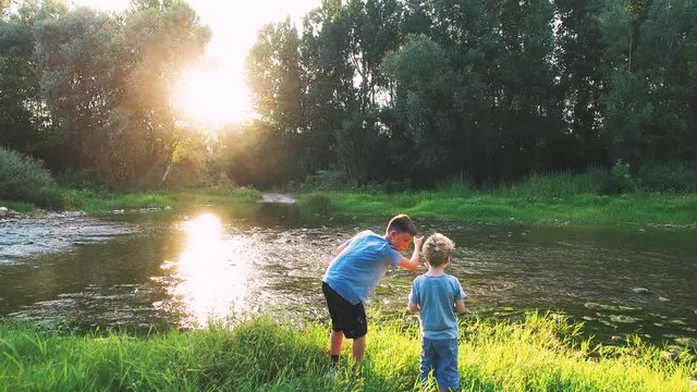 aerial shot of two Kids playing at a river in wild nature