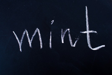 The word "mint" crayons on black blackboard