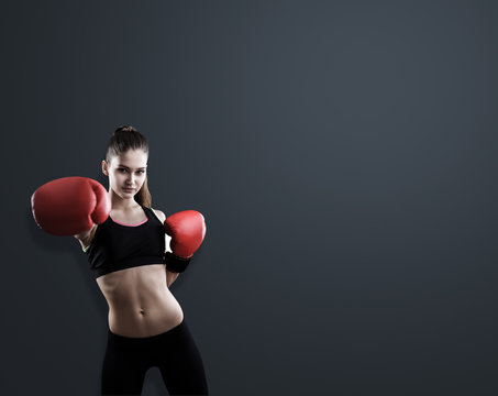 Woman boxer near black wall - Powered by Adobe