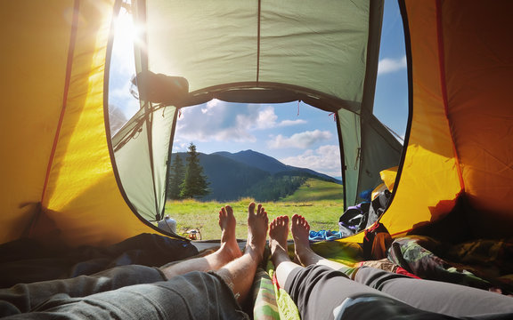Two people lying in tent with a view of mountains. Carpathians.