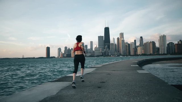 Runner athlete running on the background of skyscrapers and seaside