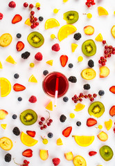 Various fresh berries and fruits scattered on a white background
