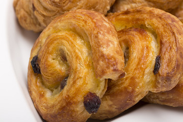 Buns on a white background/Twirl with raisins on a white plate