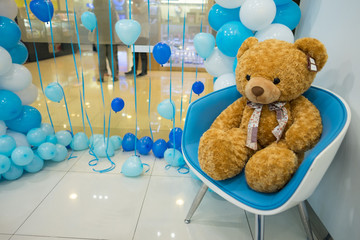 Teddy bear sit on the chair with balloon