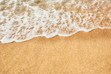 Background soft wave of Sea with foam on sandy beach.