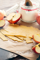 Baking Apple Pie Ingredients - fresh apples, flour, eggs and sugar on rustic dark background, selective focus. Toned image.