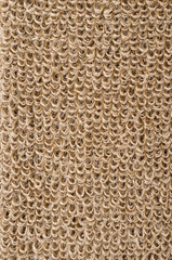 Rough flax fabric with loops. Natural flax fibres are processed to a coarse fabric, used for massage straps and gloves. Solid yarn with brown ochre color. Isolated macro photo close up.