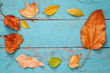 Autumn background with dry leaves on wooden table