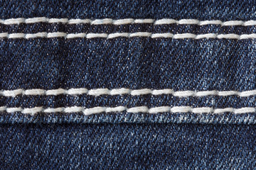 texture of dark blue jeans fabric with double seams