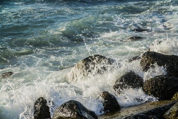Naklejka premium surf the waves off the rocky coast, large bursts of wave