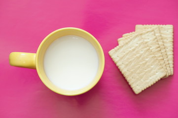 
Cup with milk and crackers are isolated on a colored background