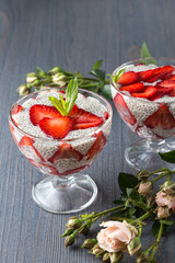 Raw vegan dessert: Chia seeds pudding with strawberries on a dark background. 