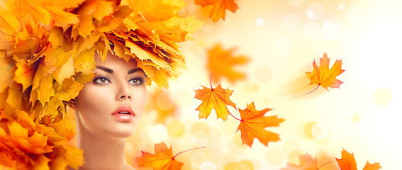 Autumn woman. Fall. Beauty model girl with autumn bright leaves hairstyle
