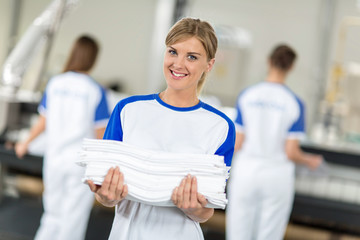 Smiling employed holding clean and ironing textiles