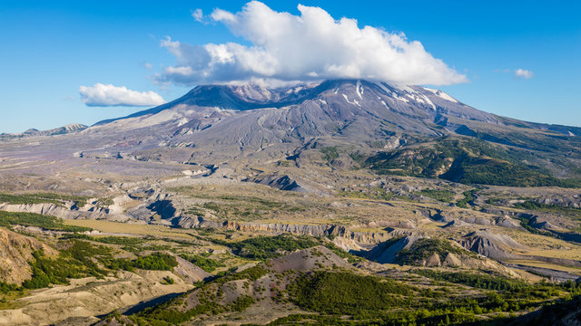 Amazing views of the Crater of Mount St Hellens. White clouds are hovering over the large crater.  Loowit Viewpoint, Mount St Helens National Park, West Part, South Cascades in Washington State, USA