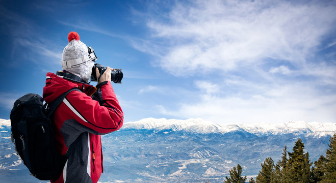 Female photographer take picture of winter landscape