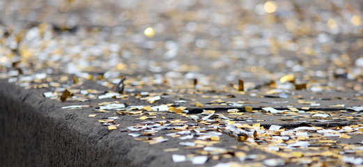 festival background with gold and silver sequins that lie on the pavement  the road  bokeh.