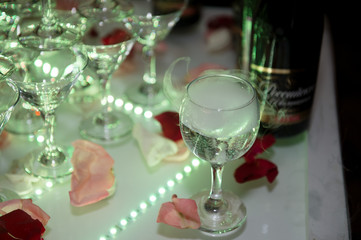A wedding decoration. Slide with champagne, highlighted by different colors. Green light, steam from dry ice