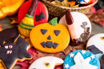 Different halloween cookies on table with autumnal leaves