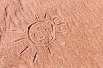 Fototapeta na wymiar Smiling sun drawing on Baltic sea beach