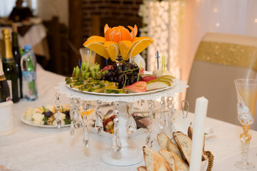 Fruit bowl on the wedding table. Pears, apples, grapes, kiwi orange