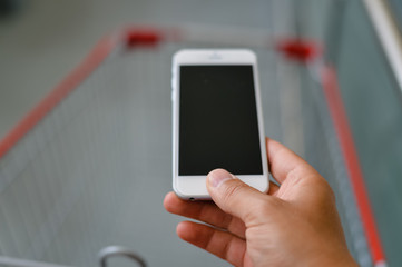 Closeup on e shopping with smart phone in human hand