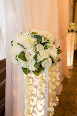 Wedding floristry. Arrangement of peonies on the high luminous rack.
