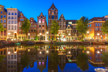 Night city view of Amsterdam canal Herengracht with typical dutch houses and their reflections, Holland, Netherlands.