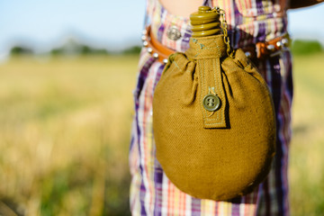 Close up on water bottle attached to the belt, sunny outdoors background