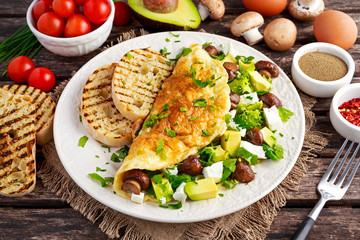 Mushroom, Feta Cheese egg Omelette witch Avocado, vegetables, lettuce, herbs and grilled bread.