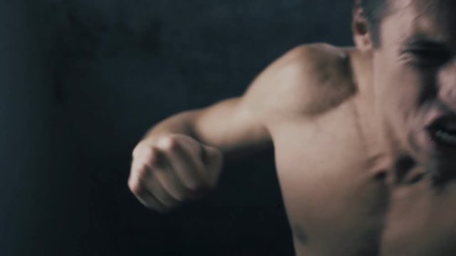 aggressive man with long hair fighting fists in slowmotion
