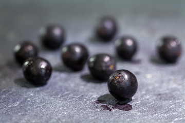 some elderberries on a blue-gray slate plate, macro shot with selected focus