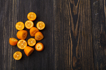 Fototapeta na wymiar kumquat on a black wooden background 