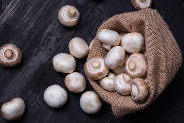 champignon mushrooms on the wood black table 